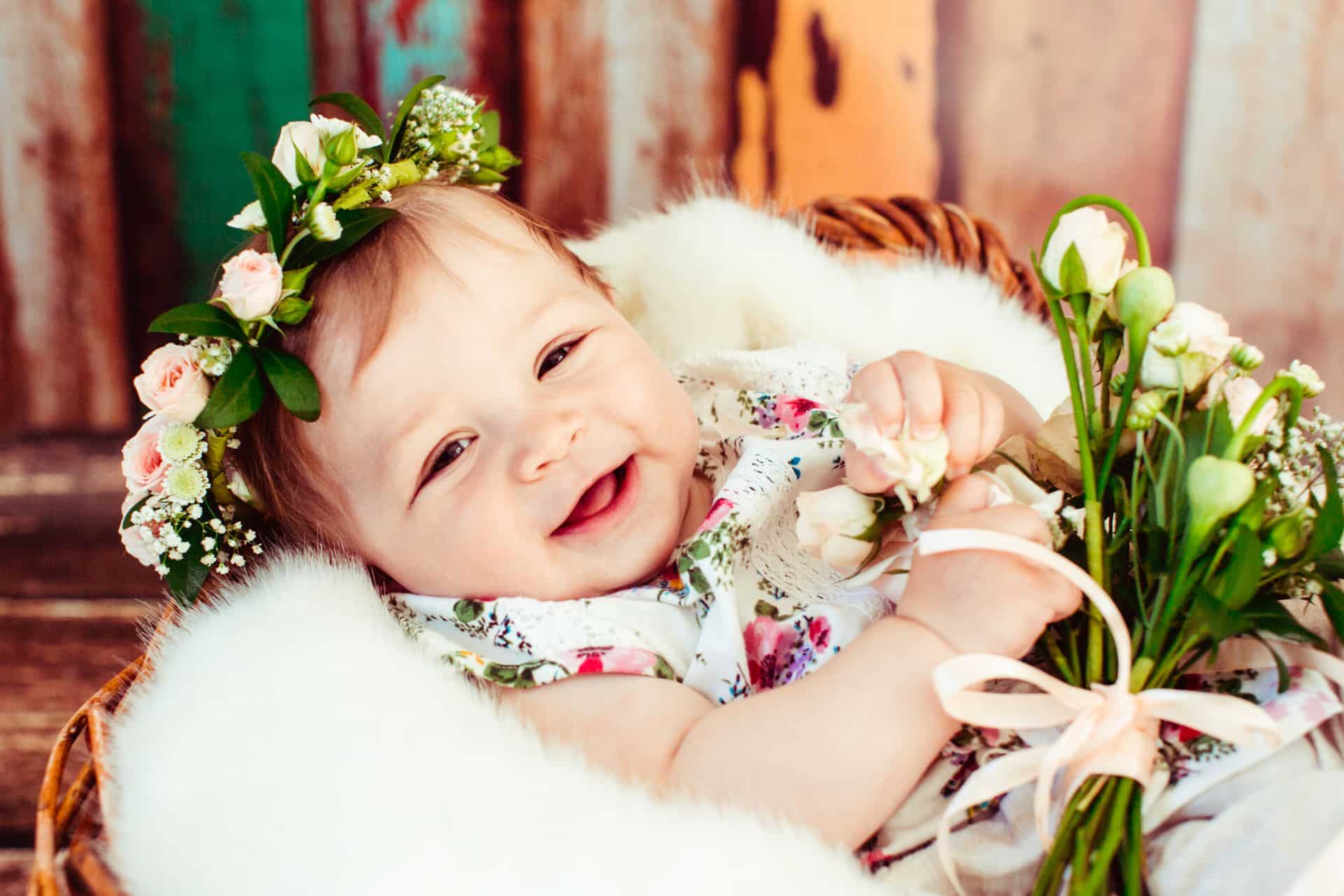 Spring baby names 2023 - baby with spring flowers in basket