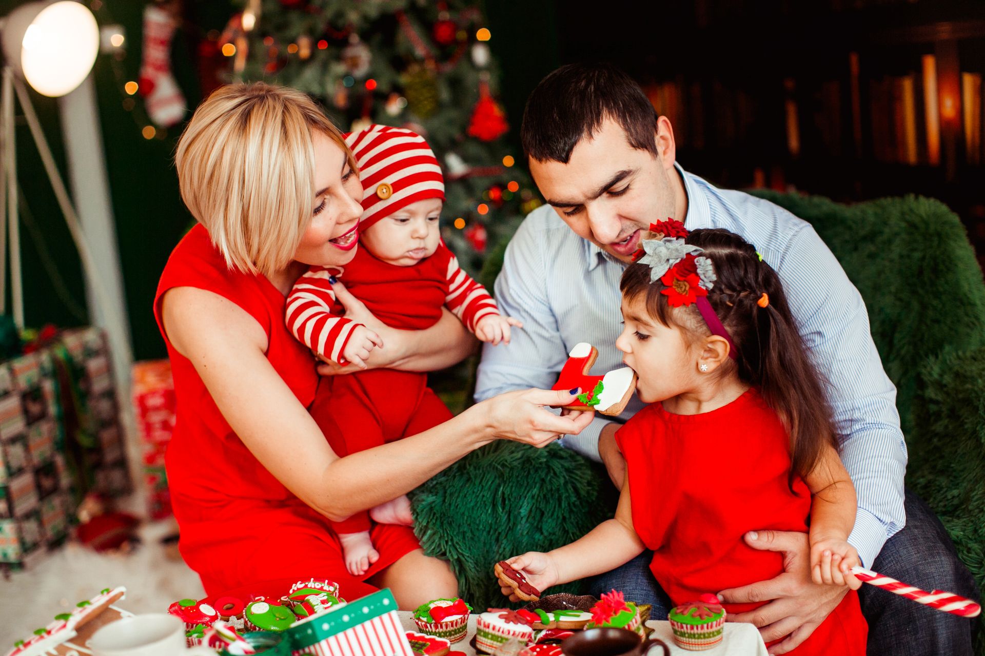 Family at Christmas - girl eating biscuit and mother holding baby