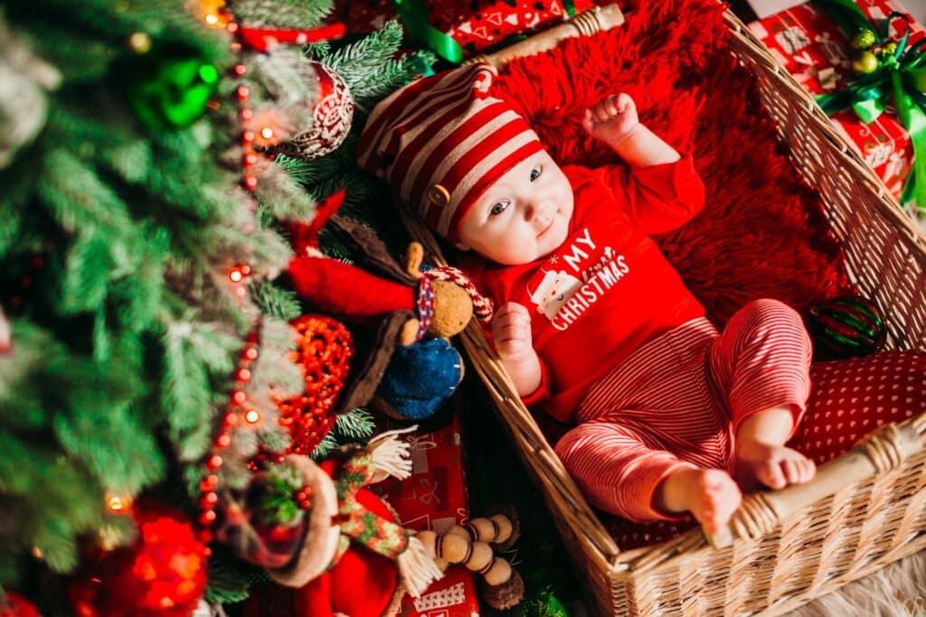 Baby in basket under tree - first Christmas