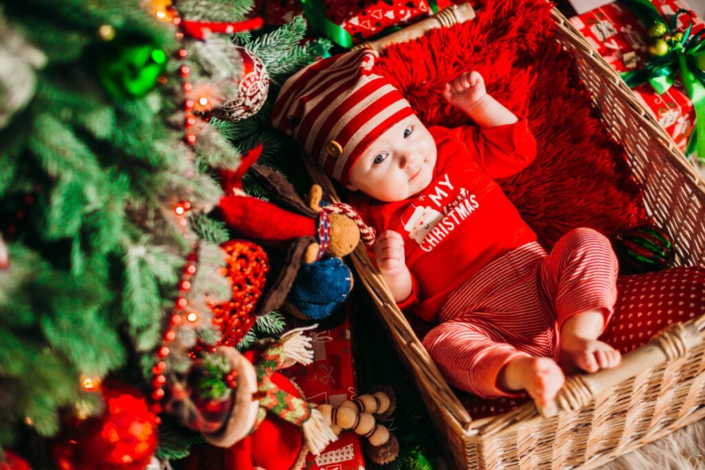 Baby in basket under tree - first Christmas